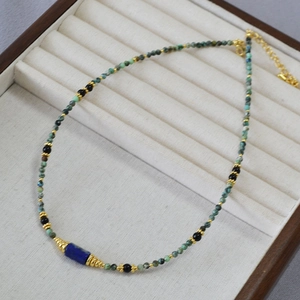 Collier bohème en perles de turquoise et lapis-lazuli avec fermoir doré sur plateau