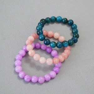 Macro view of 10mm Kunzite and Apatite beaded stretch bracelets with smooth texture