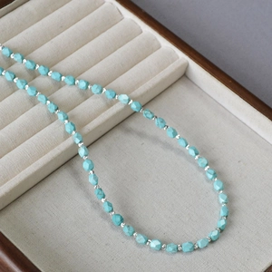 Detailed close-up of vintage faceted turquoise beads and silver spacers on a velvet display