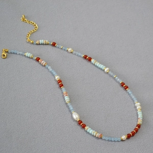 Detail of colorful beaded necklace with pearls, stones and gold lobster clasp