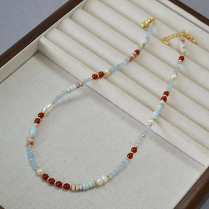 Detailed macro view of bohemian handmade necklace with colorful beads and natural pearls