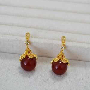 Close-up of vintage gold plated flower earrings with red agate and zircon stones