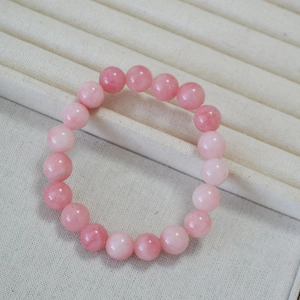Macro shot of 10mm pink kunzite beaded bracelet on a velvet display tray showing texture