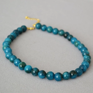 Detail of dark blue apatite beads and golden adjustable chain on minimalist necklace