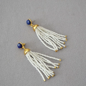 Detail of lapis lazuli beads and white seed bead tassels on vintage long gold earrings