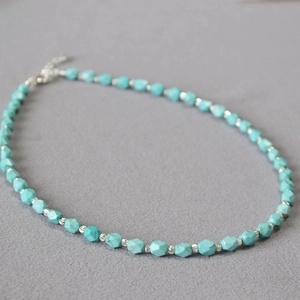 Detail of faceted turquoise bead necklace with silver spacers and lobster clasp