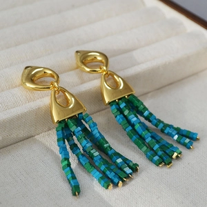 Detail of vintage gold geometric earrings with green and blue square beaded tassels