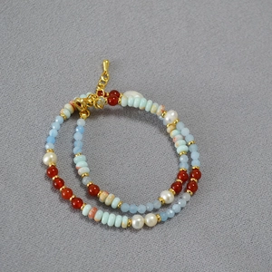 Detail of layered beaded necklace with blue agate, freshwater pearls and gold lobster clasp