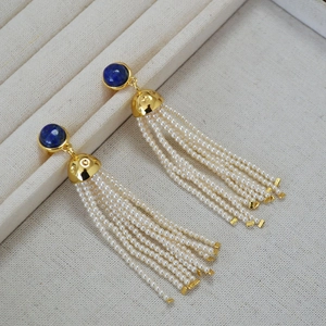 Detailed shot of retro tassel earrings featuring blue lapis stone and white seed pearls