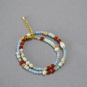 Close-up of double-layer necklace with blue stones, pearls and agate beads detail