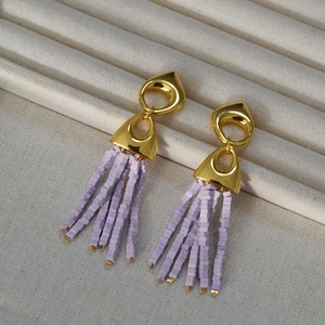 Vintage gold geometric drop earrings with elegant lavender beaded tassels on a soft fabric