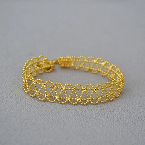 Elegant French vintage gold lace hollow geometric bracelet on grey textured fabric