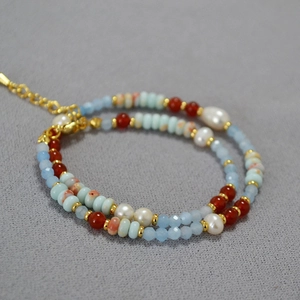 Detail of beaded necklace featuring freshwater pearls, blue stone beads and agate