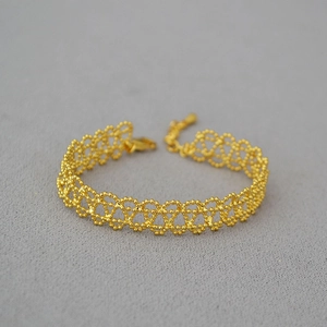 Macro detail of French vintage gold mesh bracelet featuring lace-like beaded hollow pattern