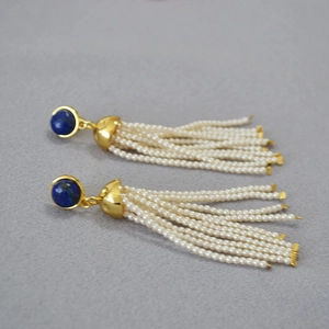 Detailed close-up of lapis lazuli drop earrings with delicate white bead tassel strands