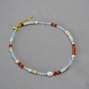 Detail of beaded necklace with blue agate pearls and gold-plated lobster clasp closure