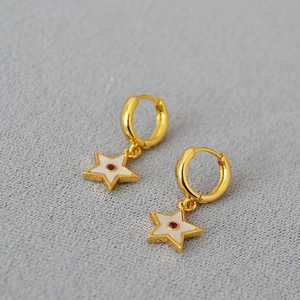 Golden hoop earrings with white enamel star charms and central red zircon stones