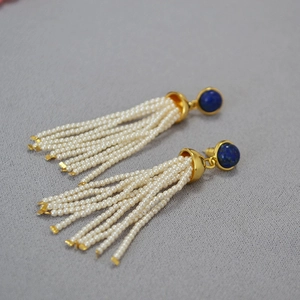 Macro view of vintage tassel earrings with deep blue gemstones and white seed beads