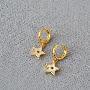 Detail of gold-plated star earrings featuring white shell inlay and green zircon center