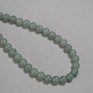 Macro detail of light green apatite beads on a minimalist vintage necklace strand