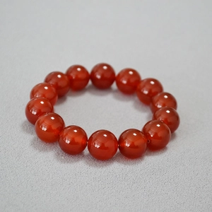 Vue macro de perles d'agate rouge polies de 14mm montrant la texture lisse et brillante