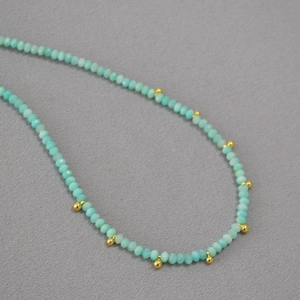 Détail de perles d'amazonite facettées vert menthe avec accents métalliques dorés
