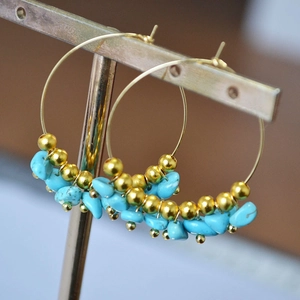 Bohemian gold hoop earrings featuring irregular turquoise beads and metallic accents