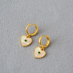 Detailed close-up of heart charm earrings with white mother of pearl and green zircon inlay