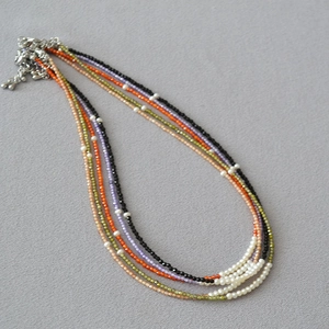 Macro detail of multilayered beaded necklace with colorful faceted beads and white pearls