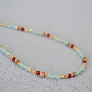 Vue détaillée du collier bohème fait main avec perles en verre et textures en bois
