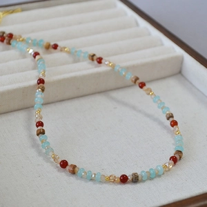 Vue détaillée du collier de perles ethniques avec perles bleues, rouges et bois sur velours