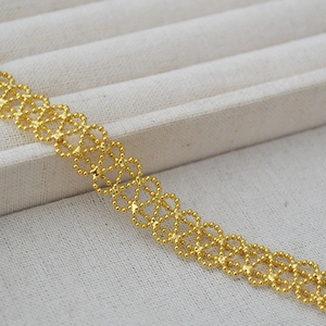 Macro detail of French vintage gold woven mesh bracelet with lace-like beadwork texture