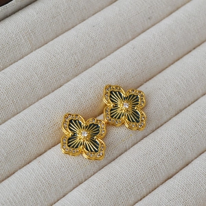 Golden clover earrings with blue enamel, starburst lines, and sparkling zircon accents