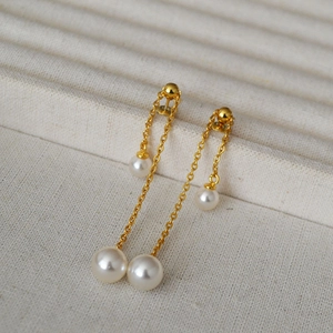 Close-up of elegant gold chain drop earrings featuring multiple white pearls and s925 needles