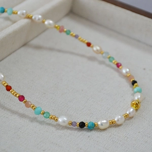 Détail du collier de perles d'eau douce avec pierres précieuses colorées et perles dorées