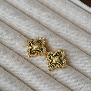 Detail of clover earring with dark blue enamel, gold rays and tiny crystals inlay