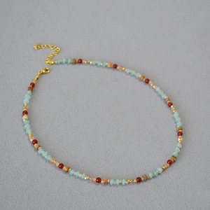 Détail du collier de perles bohème avec perles bleues et rouges et fermoir mousqueton doré