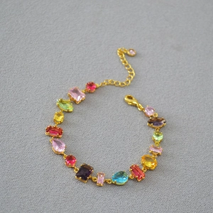 Detailed macro of colorful geometric gemstones on a gold-plated adjustable bracelet