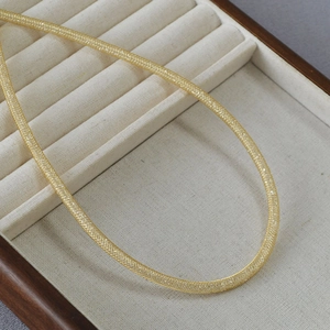 Detailed macro view of high-end gold plated brass mesh chain with woven texture