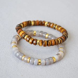 Macro shot of tiger eye beads and grey agate bracelet with gold spacer cylinders
