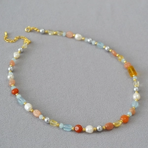 Dettaglio della collana di perle barocche con pietre semipreziose e chiusura oro