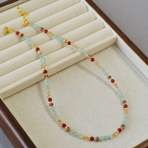 Détail du collier de perles bleues et rouges sur un plateau de présentation