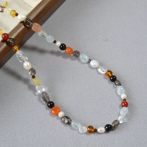 Detailed close-up of colorful irregular natural semi-precious stones and pearl necklace