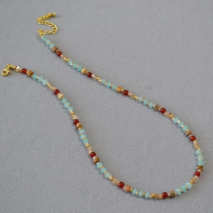 Détail d'un collier bohème fait main avec perles d'agate et fermoir mousqueton doré