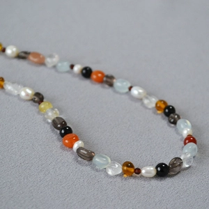 Macro shot of colorful mixed semi-precious stone beads and pearls on the necklace