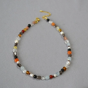 Detailed close-up of mixed natural semi-precious stone and pearl beaded necklace