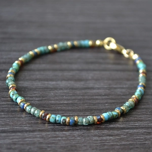 Macro shot of handmade Miyuki bead bracelet with turquoise stones and gold spacers