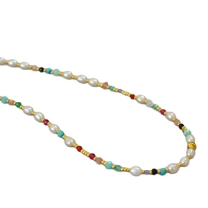 Collier d'été en perles colorées avec perles d'eau douce et pierres sur fond blanc