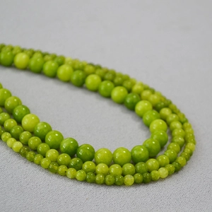 Gros plan d'un collier de perles en pierre vert olive multicouche au fini poli
