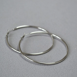 Detailed view of large silver oversized hoop earrings with smooth polished finish